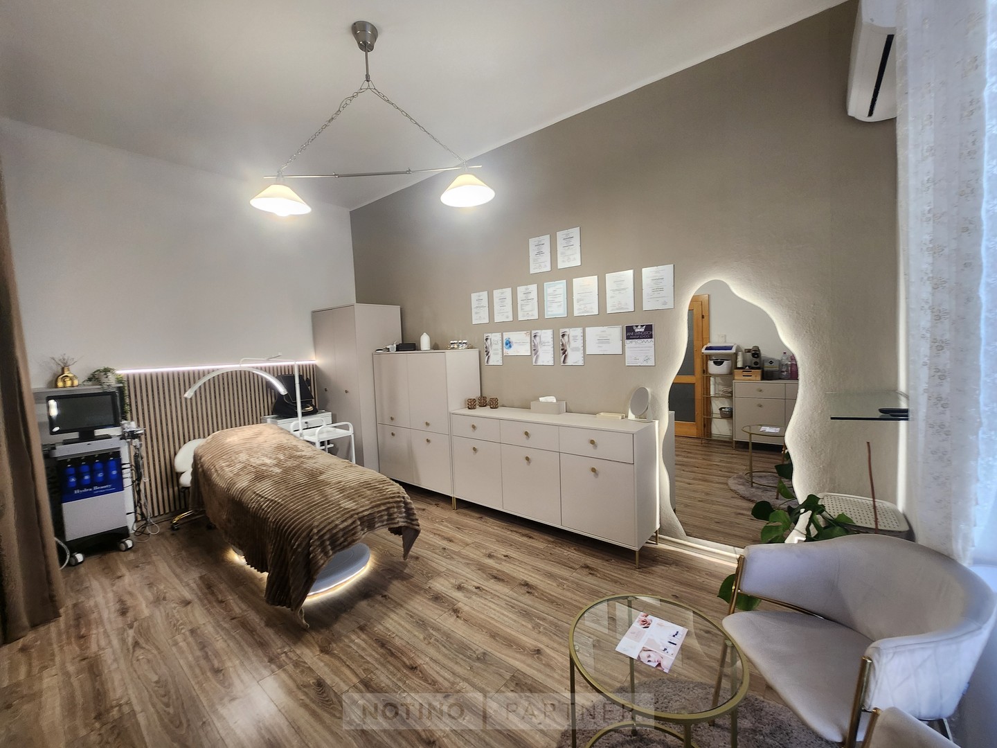 Pokojný interiér The Skin Room s kozmetickým kreslom, zrkadlom a posedením